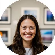 Alyea Cruse smiling in front of framed photographic prints at a gallery wall