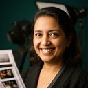 Jerelyn Kavandi smiling beside a contact sheet in a softly lit studio